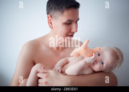 Father with his young baby cuddling and kissing him on cheek. Parenthood, love. Stock Photo
