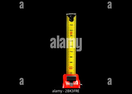 repair and construction concept. red with black construction roulette isolated on a black background close up. front view with copy space for text. Stock Photo