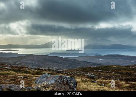 View  of the dramatic stormy sunset from Applecross mountain pass to the Island of Skye with Cuillin mountain range Stock Photo
