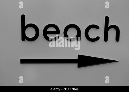 The black word beach of hanging on a gray wall. pointer arrow beach right Stock Photo