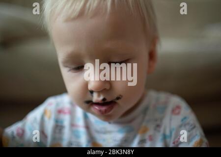 the child was stained with black paint. Stock Photo