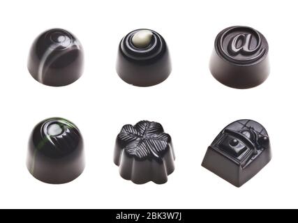 Luxury dark chocolate truffles. Assorted delicious handmade pralines in a row isolated on white. Studio shot. Close-up. Stock Photo