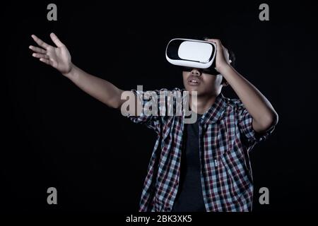 Student man wearing virtual reality goggles in studio,Smartphone using with VR headset. Stock Photo