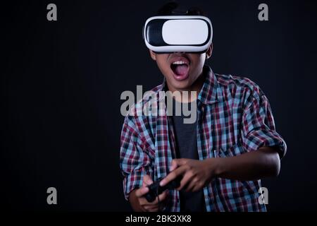 Student man wearing virtual reality goggles in studio,Smartphone using with VR headset. Stock Photo