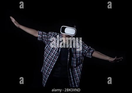 Student man wearing virtual reality goggles in studio,Smartphone using with VR headset. Stock Photo