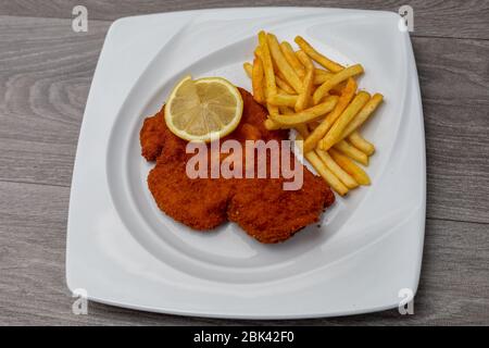 Breaded viennese schnitzel with french fries Stock Photo