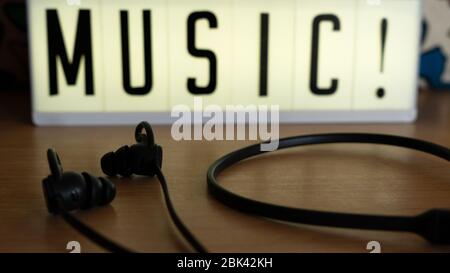 close up wireless headphones on desk with music bright sign background Stock Photo