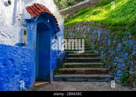 Stone Stairs up a Hill next to a Blue Cottage in Chefchaouen Morocco Stock Photo
