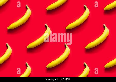 Pattern of yellow bananas on a red background. Stock Photo