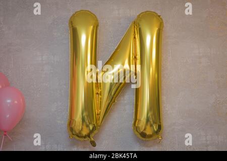 N For Best Friends Forever made of golden inflatable balloon letters . Word N written with helium golden balloons . Stock Photo