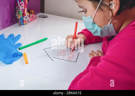 Little young girl with Stay Home draw. Coronavirus quaranatine concept Stock Photo
