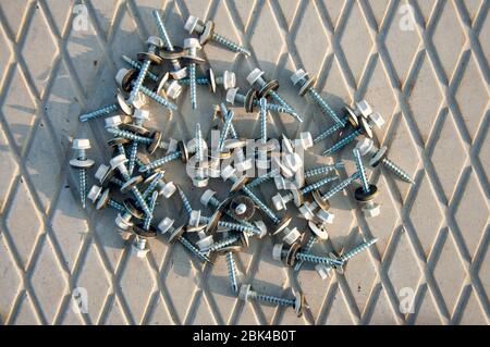 Roofing screws for fastening steel sheets. Hardware for construction. Self-tapping screws for fixing the roof Stock Photo