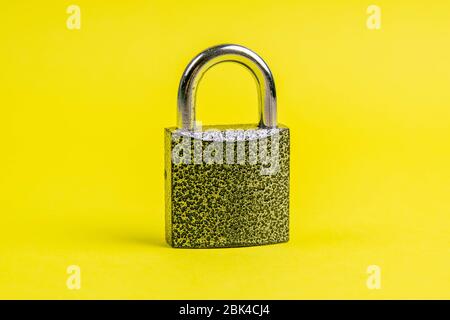 Macro of a locked padlock on yallow bacground. Close-up Stock Photo