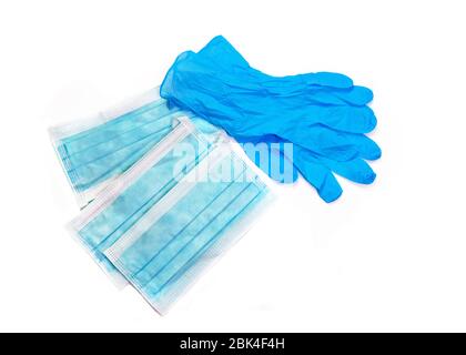 personal protective equipment pair of blue latex gloves with a face mask , that you might wear to portect you from a virus , isolated on a white backg Stock Photo