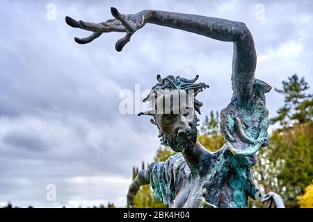 Statue of strange looking man with his hand lifted up. Stock Photo