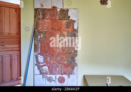 Old wooden door and tile stove in the wall Stock Photo