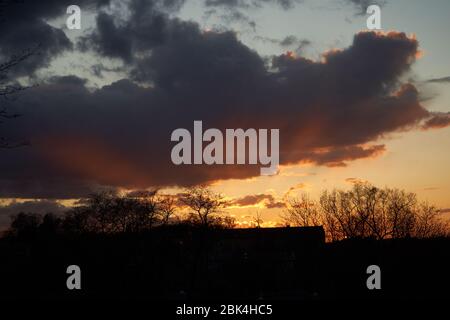 Sunset in the dark clouds at spring time Stock Photo