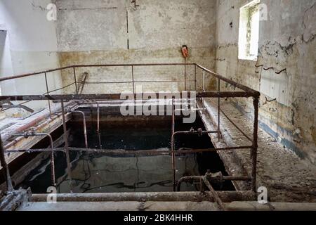 Abandoned factory building with water pool inside Stock Photo