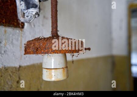 Old rusty lamp holder in abandoned building Stock Photo
