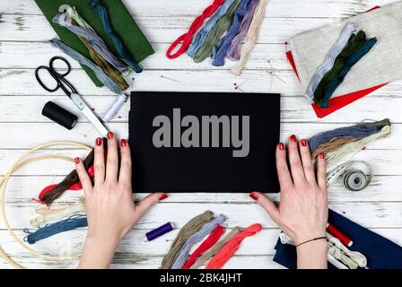 there are quilting, embroidery and sewing tools on the table. patchwork knife, scissors, lined cutting mat, self-locking, threads, measuring tape, flo Stock Photo