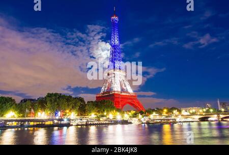 The Eiffel tower lit up with the colors of French national flag. Stock Photo