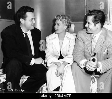 ORSON WELLES and RITA HAYWORTH with Set Visitor Gilda co-star GLENN FORD candid during filming of THE LADY FROM SHANGHAI 1947 director / screenplay ORSON WELLES based on novel by Sherwood King gowns Jean Louis Columbia Pictures Stock Photo