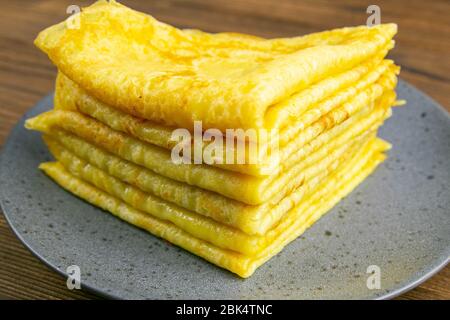 Pancake in gray plate on wooden table. Top views, close-up Stock Photo