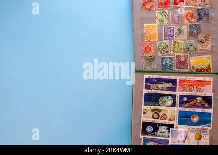 A collection of post stamps in two post albums on blue background. Top view. Stamps collecting hobby. Stock Photo