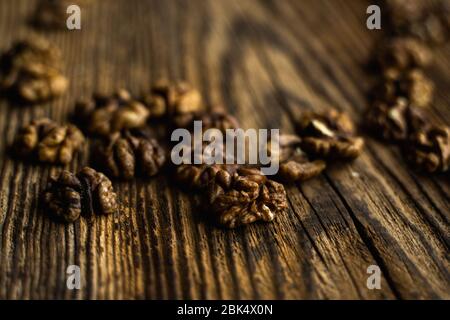 Walnut scattered on the wooden vintage table. Copy space. Walnuts is a healthy vegetarian protein nutritious food. Almonds on rustic old wood. Stock Photo