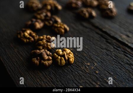 Walnut scattered on the wooden vintage table. Copy space. Walnuts is a healthy vegetarian protein nutritious food. Almonds on rustic old wood. Stock Photo