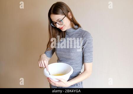 woman in t-shirt and jeans preparing homemade cupcakes in her kitchen Stock Photo