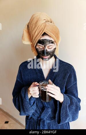 millennial put a black mask on her face and tied a towel on head Stock Photo