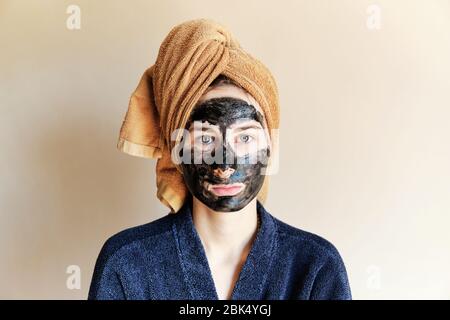 millennial put a black mask on her face and tied a towel on head Stock Photo