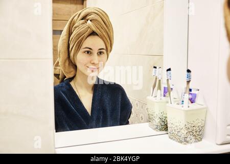 young millennial performs cosmetic procedures in front of a mirror Stock Photo