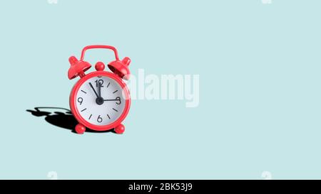 Red analog clock on a turquoise background. Copy place. Close up. Stock Photo