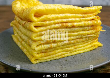 Pancake in gray plate on wooden table. Top views, close-up Stock Photo