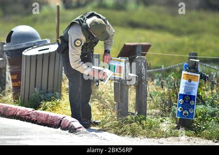 Pacific Grove, California, USA. 1st May, 2020. California State Parks Peace Officer posting signs to clarify the.Recreation Rules for Asilomar State Beach during the COVID-19 Shelter in Place Order Credit: Rory Merry/ZUMA Wire/Alamy Live News Stock Photo