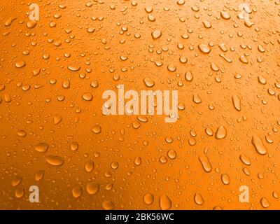 Drops of water on an orange metal surface, beautiful background after rain Stock Photo
