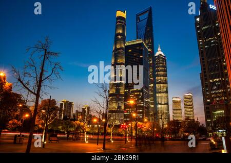 The Shanghai Tower, Jinmao Tower and Shanghai World Financial Center skyscrapers seen at during the blue hour (evening) from around Dongchang Road sub