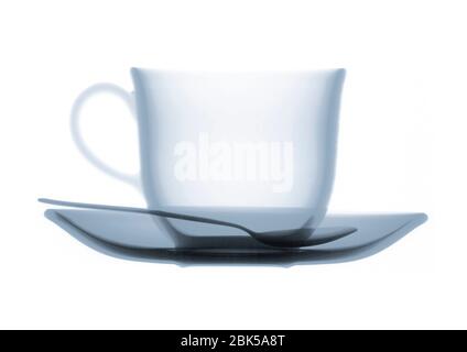 Teacup saucer and teaspoon, coloured X-ray. Stock Photo