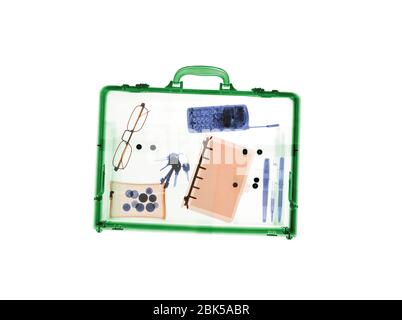 Briefcase with various items, coloured X-ray. Stock Photo