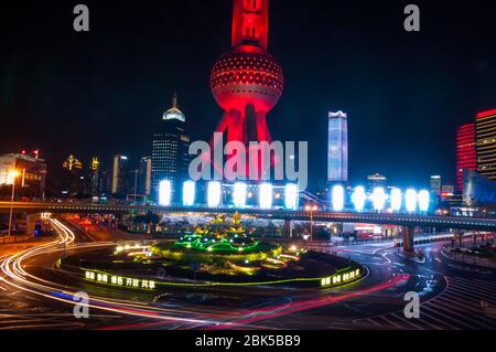 The Oriental Pearl Tower seen at night from the Lujiazui skywalk with the Mingzhu Roundabout in front. Stock Photo