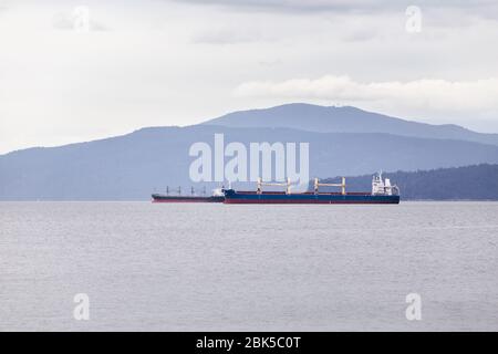 Cargo and tanker ships moored in Vancouver harbor awaiting to be loaded. Stock Photo