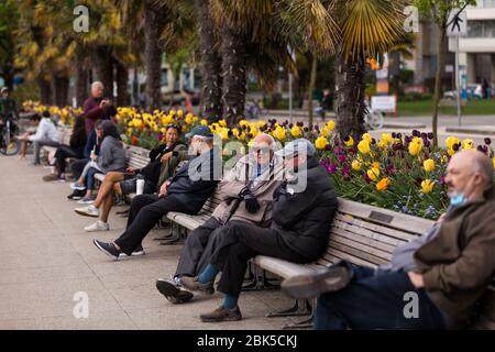 DOWNTOWN VANCOUVER, BC, CANADA - APR 26, 2020: Vancouver residents enjoying the park at English Bay during the quarantine while maintaining physical Stock Photo