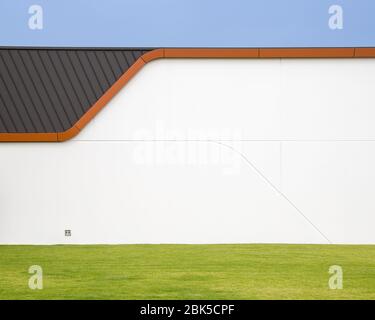 A white wall on the exterior of a large commercial building. Geometric shapes and strong colours, copy space for text Stock Photo