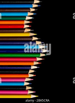 Multi colour pencils arranged on a black background. Copy space Stock Photo