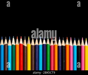 Multi colour pencils arranged on a black background. Copy space Stock Photo