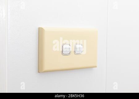 A double light switch on a white tiled wall Stock Photo