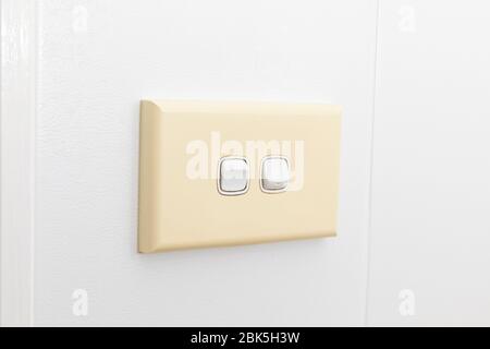 A double light switch on a white tiled wall Stock Photo