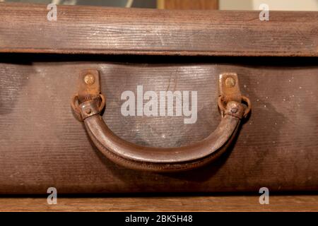 A rusty carry handle on an old brown leather suitcase Stock Photo